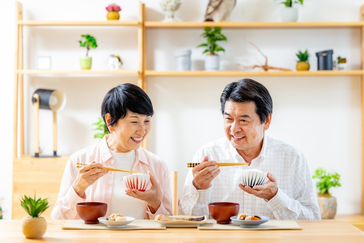 失った歯の治療を終えて快適に食事をとるミドルの夫婦