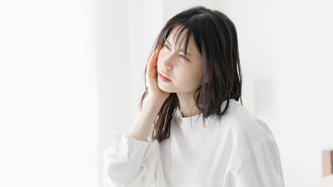 ワイヤー矯正で歯が痛い女性