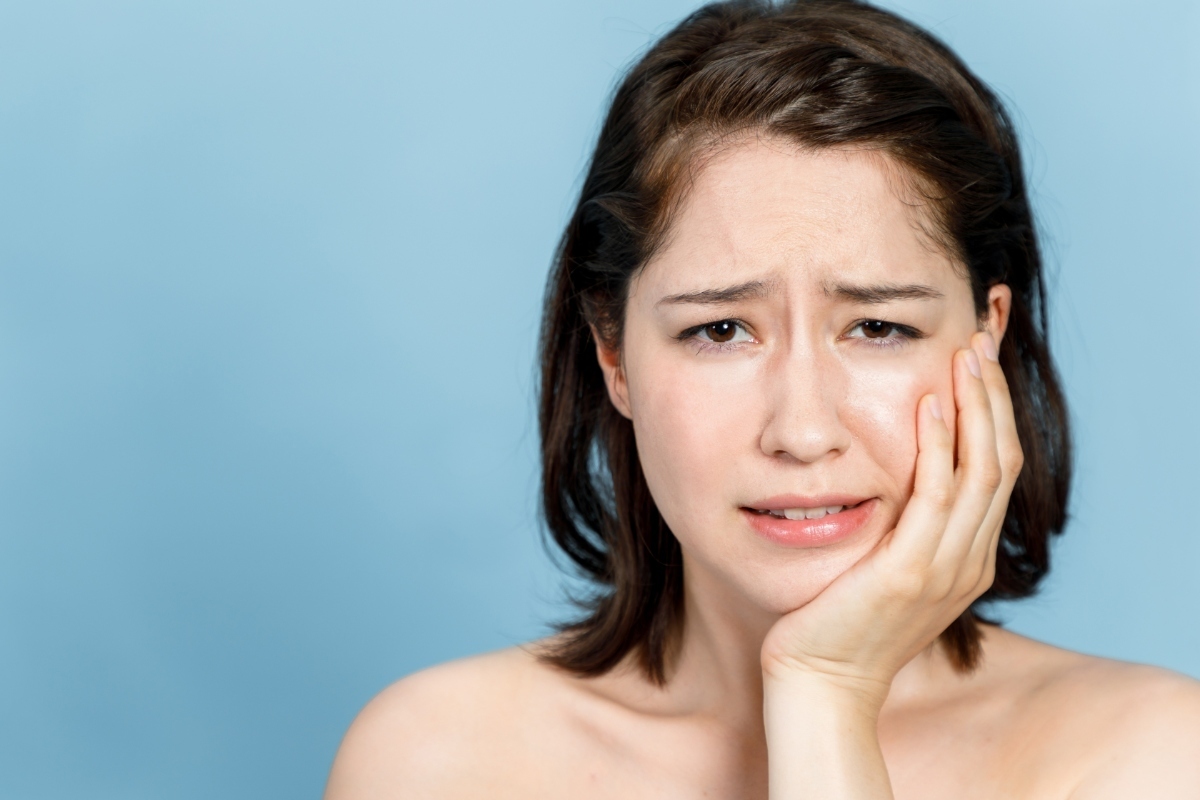 銀歯の下が虫歯になリ、歯がしみている女性