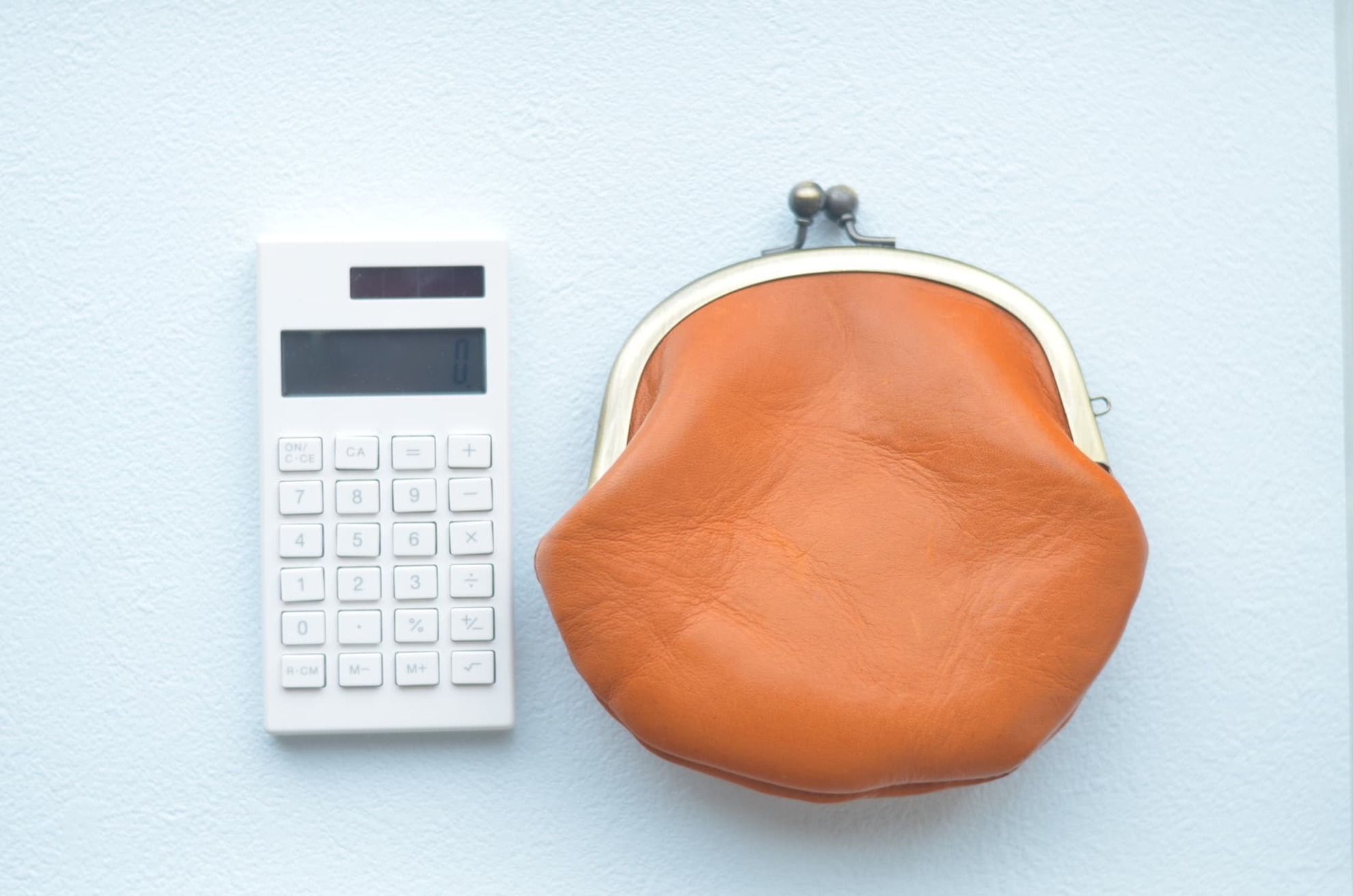 八重歯を治すのにかかる費用を示す計算機とがま口財布