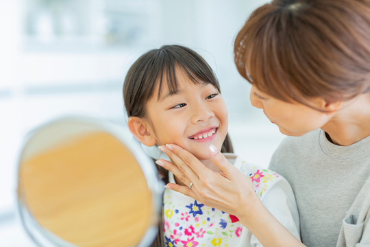子供の歯のチェックする母親